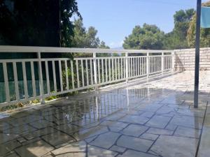 a white fence on a walkway with water on the ground at Apartment ZenPunta in Pučišća