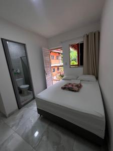 a bedroom with a large bed and a mirror at Village enseada do castelo-com carregador de carros eletricos in Praia do Forte