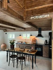 a kitchen with a table and chairs in a room at Traditional Scanian Farm In The Fields Of Österlen in Gärsnäs