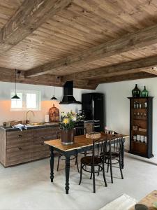 a kitchen with a table and chairs in a room at Traditional Scanian Farm In The Fields Of Österlen in Gärsnäs