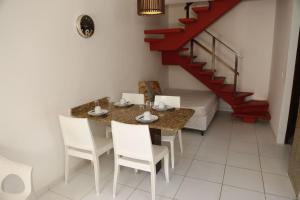 a dining room with a table and chairs and a staircase at Tamandaré Residence Beach 3 in Tamandaré