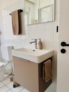 ビュッケブルクにあるCozyHomeの洗面台とトイレを備えた白いバスルーム