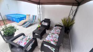 a patio with two chairs and a table with pillows at Casa Villetana in Villeta