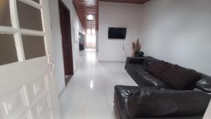 a living room with a leather couch and a television at Casa Villetana in Villeta