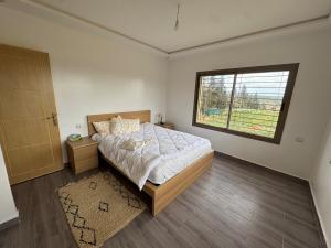 une chambre avec un grand lit et une fenêtre dans l'établissement Zs Farm Kamouni - WIFI Fibre - Jacuzzi on request, à Sidi Allal el Bahraoui