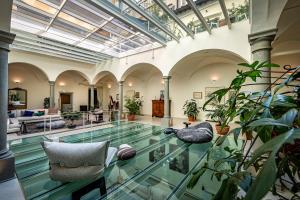 an indoor pool with chairs and plants in a building at Dimora Collection - Le Corti - Boutique Luxury Suites in a Restored 13th Century Convent, with Sauna and Gym in Florence