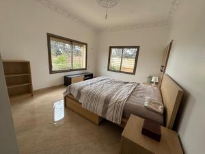 une chambre avec un grand lit et deux fenêtres dans l'établissement Zs Farm Kamouni - WIFI Fibre - Jacuzzi on request, à Sidi Allal el Bahraoui