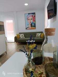 a living room with a couch and a vase with flowers at As Mimosas d'Cross in Redondela