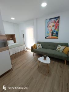 a living room with a green couch and a table at As Mimosas d'Cross in Redondela