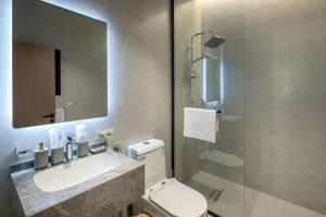 a bathroom with a toilet and a sink and a mirror at Delmar Luxury 3BR Apartment 4 in Jeddah +18 photos