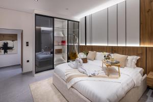 a bedroom with a large bed with towels on it at Delmar Luxury 3BR Apartment 4 in Jeddah