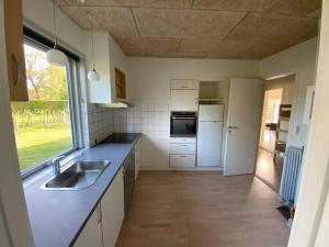 a kitchen with a sink and a refrigerator at Billund Sol Center House in Billund