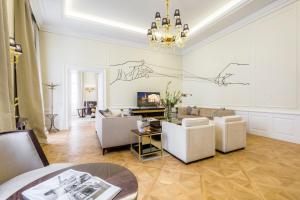 a living room with white furniture and a chandelier at Residence Wollzeile in Vienna