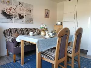 a dining room with a table and two chairs at Ferienwohnung Irene in Strackholt in Großefehn 