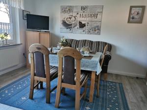 a dining room with a table and a couch at Ferienwohnung Irene in Strackholt in Großefehn 