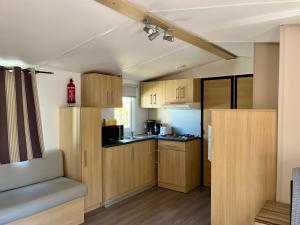 a small kitchen with wooden cabinets and a counter top at Évasion famille - Dune Blanche in Camiers