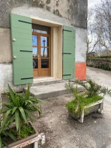 Una casa con persianas verdes en el frente. en Maison Goya Arlésienne, en Arles