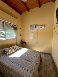 a bedroom with a bed and a window and a fan at El patio apart in Esquina