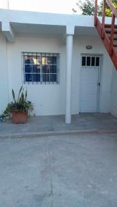 a white house with a garage with a door at El patio apart in Esquina