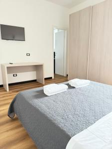 a bedroom with a bed and a tv on a wall at Infinity House - Eleganza Moderna tra Treviso e Venezia in Casièr