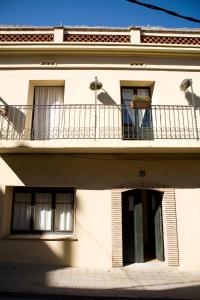 - un bâtiment blanc avec un balcon et une fenêtre dans l'établissement L'Escala - Pintor Massanet, à L'Escala