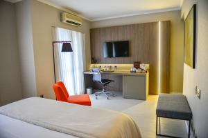 una camera d'albergo con un letto e una scrivania di Clarion Faria Lima a San Paolo