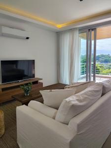 a living room with a white couch and a television at Depto 2 Dorm en Posadas - Lomas de Alem in Posadas