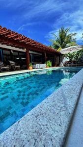 a swimming pool in front of a house at Sun House Manguinhos in Búzios