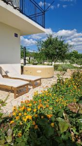 Un patio con dos bancos y un ramo de flores. en Villa Dona Bella, en Donji Bitelić