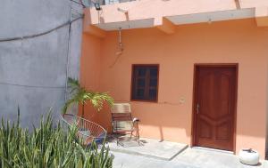 a house with two chairs and a wooden door at Casa Valdez in Valladolid