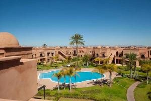 an aerial view of a resort with a pool and palm trees at La Perle de l'Atlas by Golf Resort in Marrakesh
