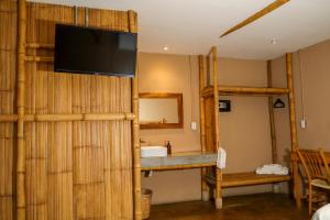 シウダー・バージェスにあるEco Hotel Casa Kimaの竹の壁にテレビが付いたバスルーム