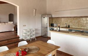 Una cocina con una mesa y un refrigerador y una habitación. en Son Floriana, en Son Servera