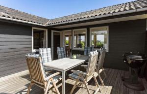 a wooden table and chairs on a patio at 3 Bedroom Beautiful Home In Hesselager in Hesselager +10 photos
