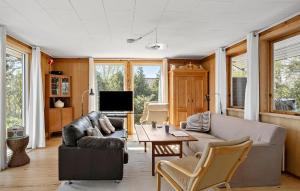 a living room with a couch and a table at 3 Bedroom Beautiful Home In Hesselager in Hesselager