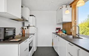 a kitchen with white cabinets and a sink at 3 Bedroom Beautiful Home In Hesselager in Hesselager