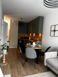Una sala de estar con mesa y sillas y una cocina. en Przystań na Tatarskiej, en Przemyśl