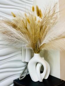 a white vase with feathers in it on a table at Jessa Rios Coast Staycation in Manila