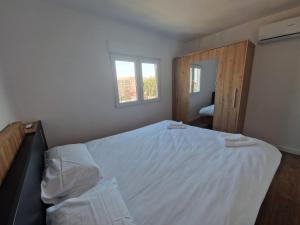 Un dormitorio con una cama blanca y una ventana. en Paz Central Tower - Pets OK, en Castellón de la Plana