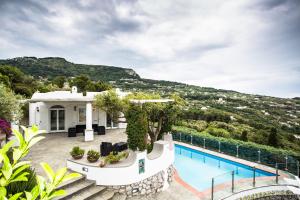 a house with a swimming pool and a mountain at Villa Mascia in Anacapri