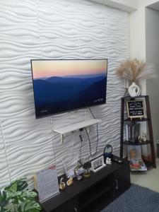 a flat screen tv hanging on a wall at Jessa Rios Coast Staycation in Manila
