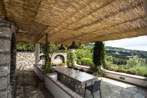 patio con tavolo e tetto in legno di Villa Mascia ad Anacapri