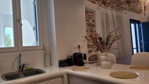 a kitchen counter with a sink and a window at Ankon Beach House Kythnos in Kithnos +30 photos