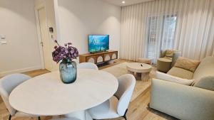 a living room with a vase of flowers on a table at Lustica Bay Centrale 7a4 in Tivat