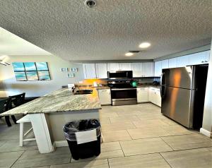代托纳海滩Vacation in Comfort and luxury - 3 BR Direct Oceanfront - Wyndham Ocean Walk Resort 2425的带柜台和冰箱的厨房