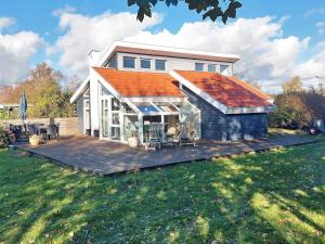a house with an orange roof on a wooden deck at 6 person holiday home in Karrebæksminde-By Traum in Karrebæksminde