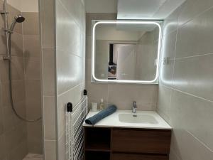 a bathroom with a sink and a mirror at Chez Camille & Emma - Hyper Centre Climatisé in Rochefort