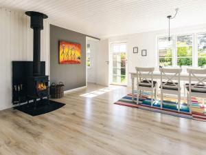 a living room with a fireplace and a dining room at Cozy Summer House Near Ore Strand in Vordingborg