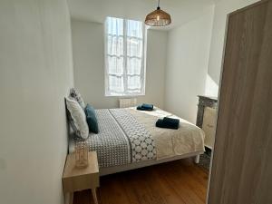 a white bedroom with a bed and a window at Chez Camille & Emma - Hyper Centre Climatisé in Rochefort +10 photos