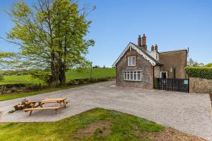 une maison en pierre avec une table de pique-nique devant elle dans l'établissement Rose cottage, à Dungannon